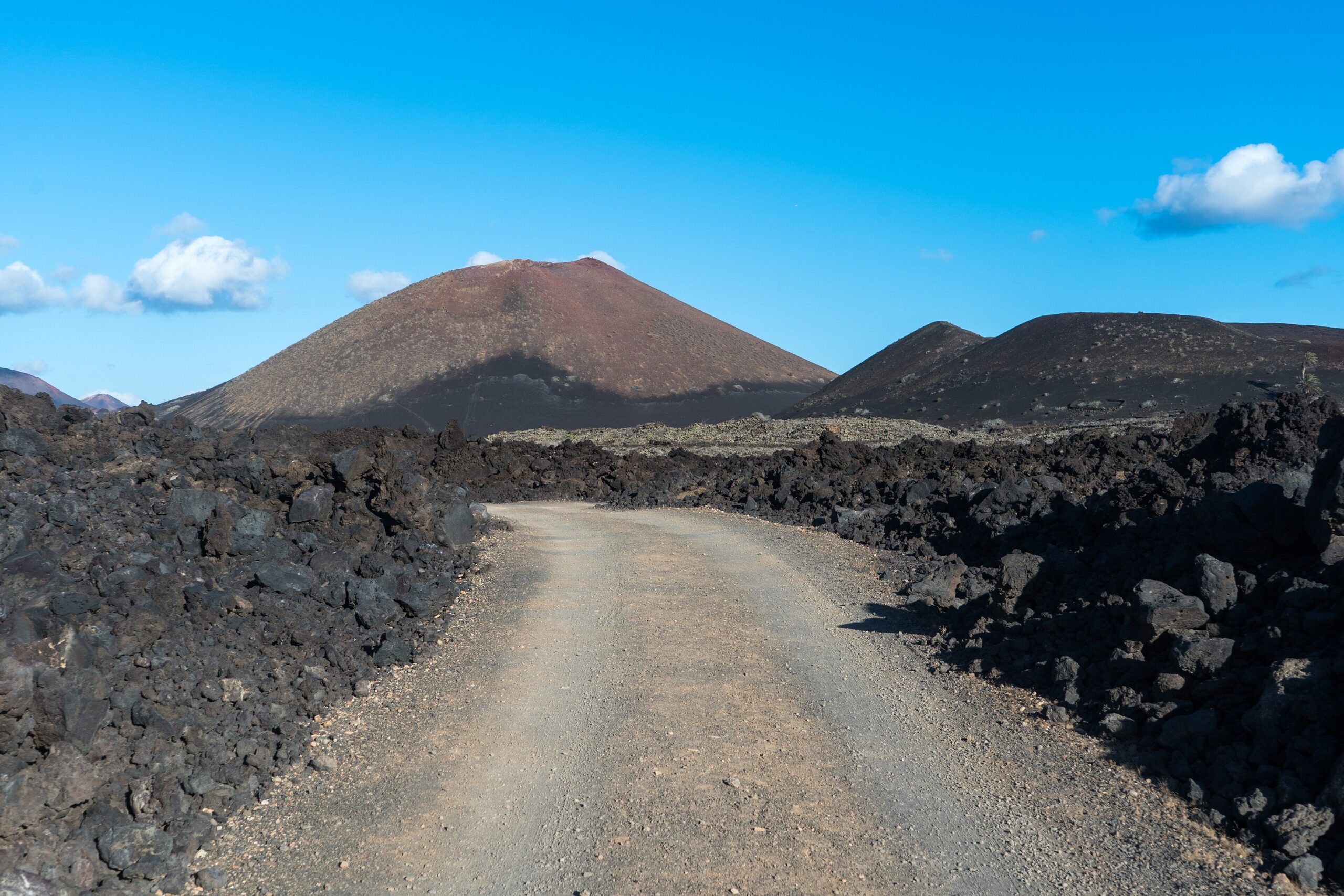 Väg genom Timanfaya nationalpark med svart lava på Lanzarote