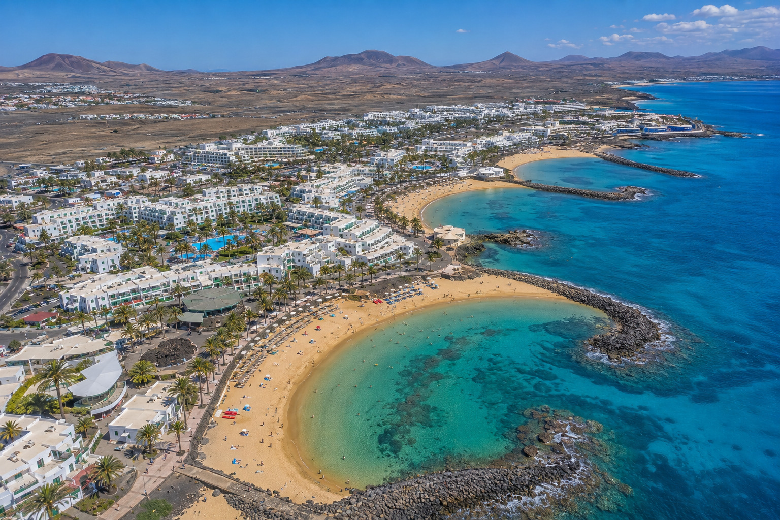 Costa Teguise på Lanzarote – helikoptervy över Playa de las Cucharas dubbelvik med vita resorter