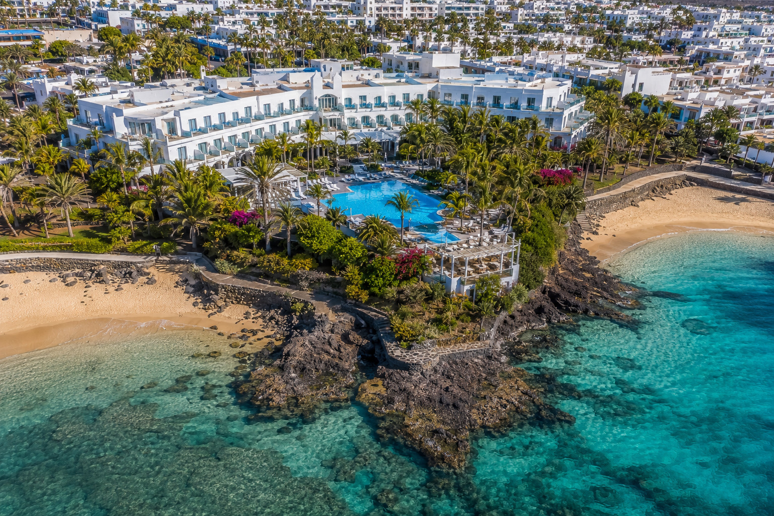 Puerto del Carmen på Lanzarote – helikoptervy över Kanarieöarnas största resort med 7 km strandremsa, vitkalkade hotell och Atlanten