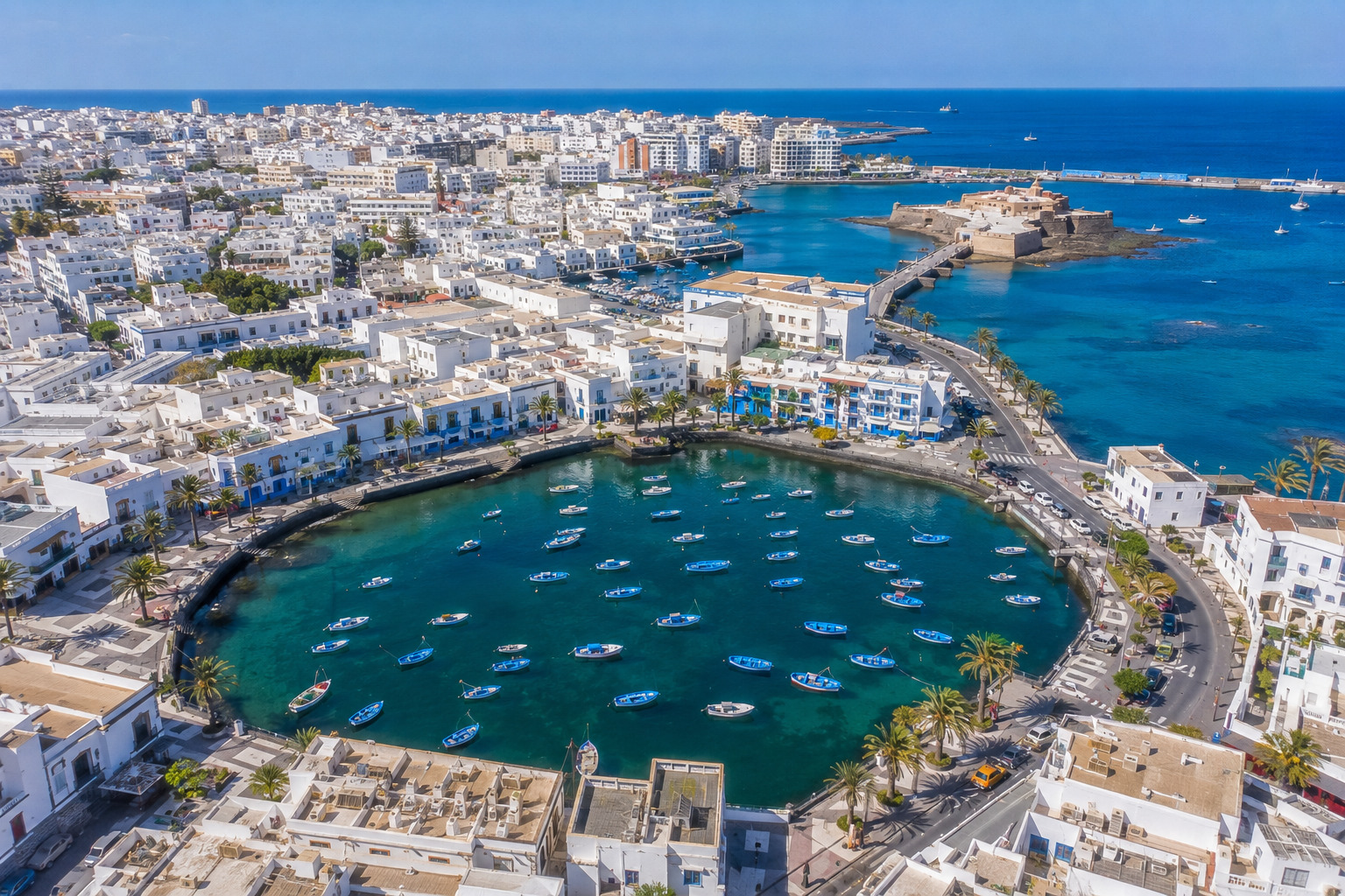 Puerto del Carmen på Lanzarote – helikoptervy över Kanarieöarnas största resort med 7 km strandremsa, vitkalkade hotell och Atlanten