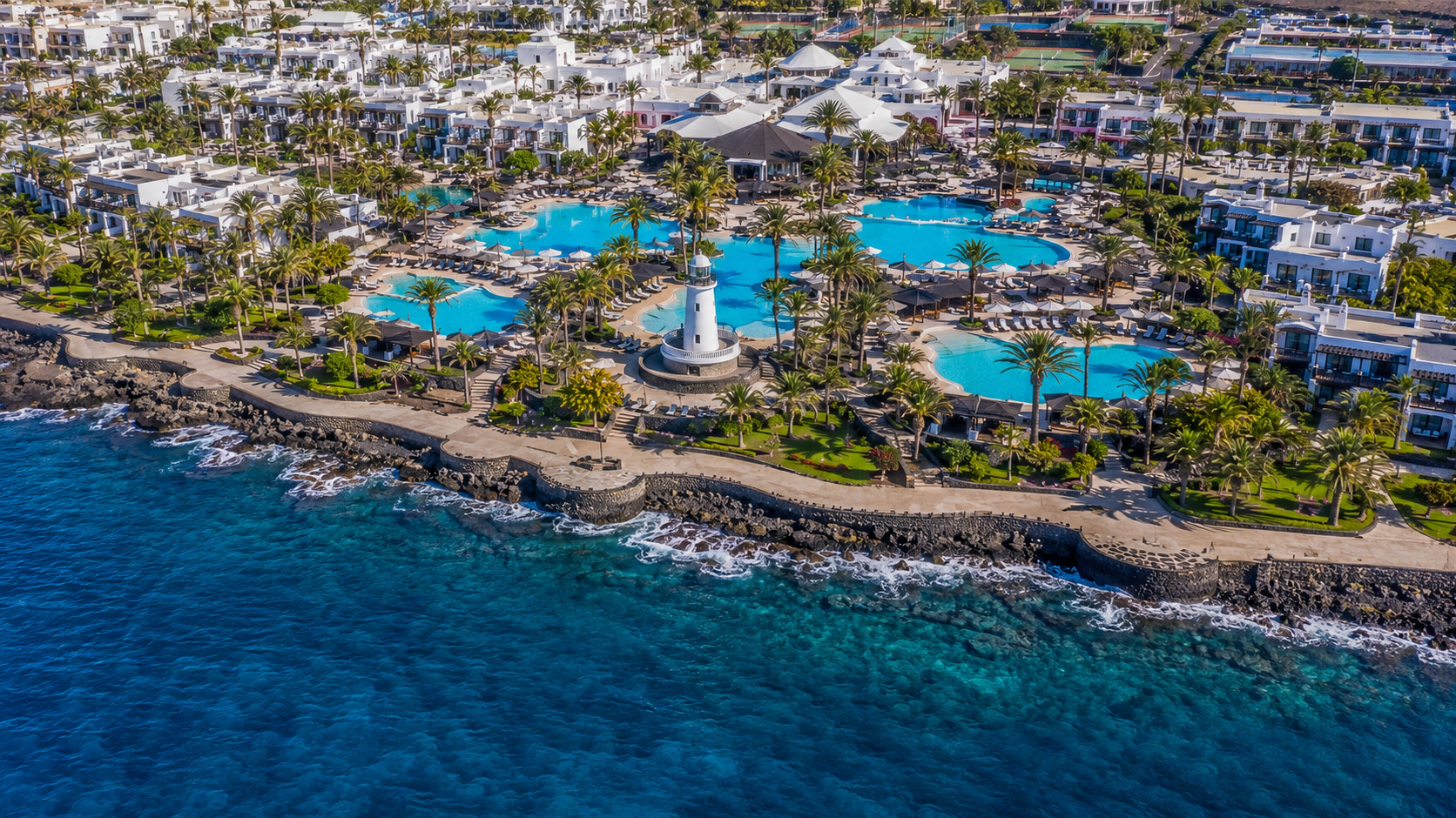 Puerto del Carmen på Lanzarote – helikoptervy över Kanarieöarnas största resort med 7 km strandremsa, vitkalkade hotell och Atlanten