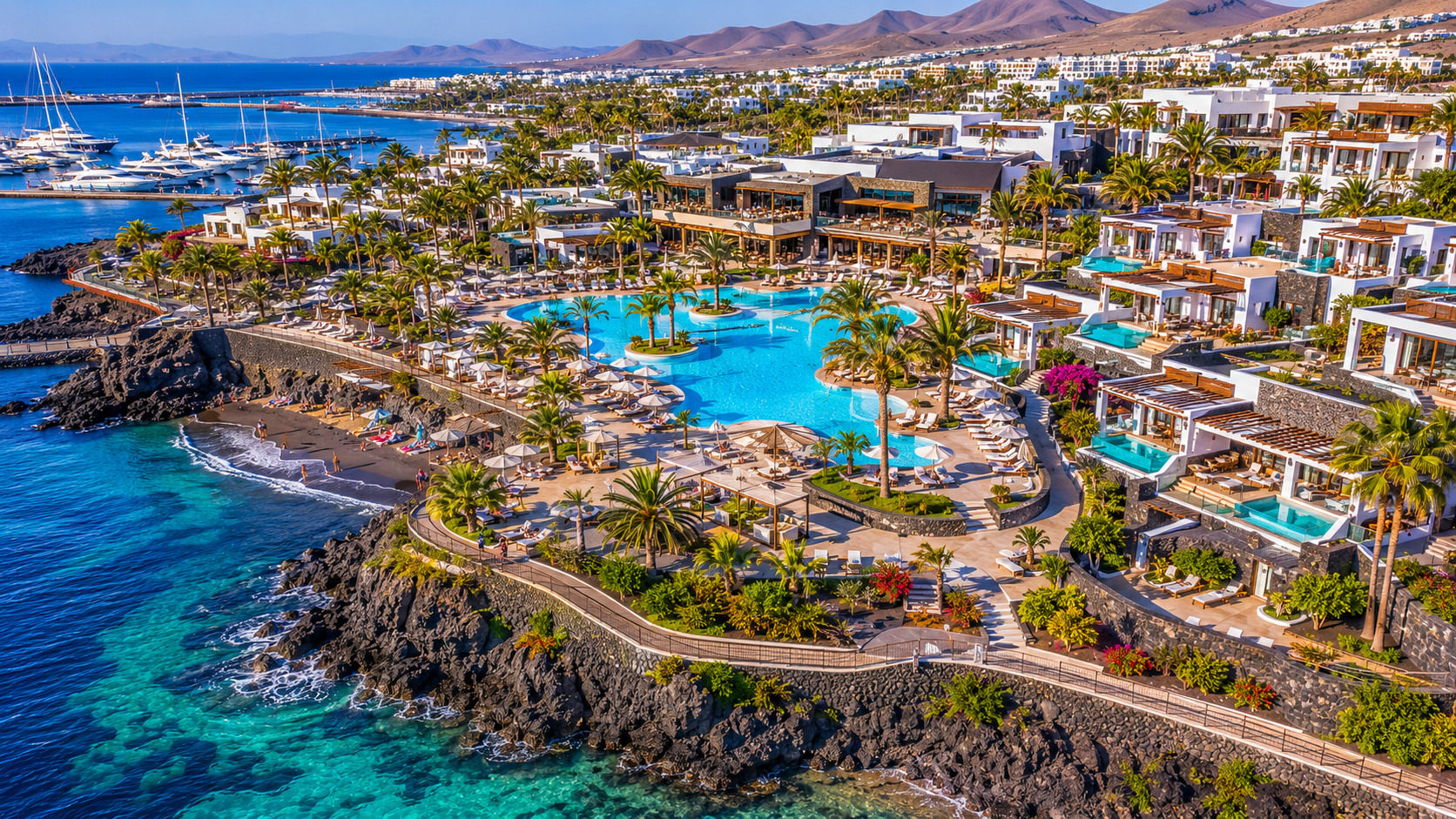 Puerto del Carmen på Lanzarote – helikoptervy över Kanarieöarnas största resort med 7 km strandremsa, vitkalkade hotell och Atlanten