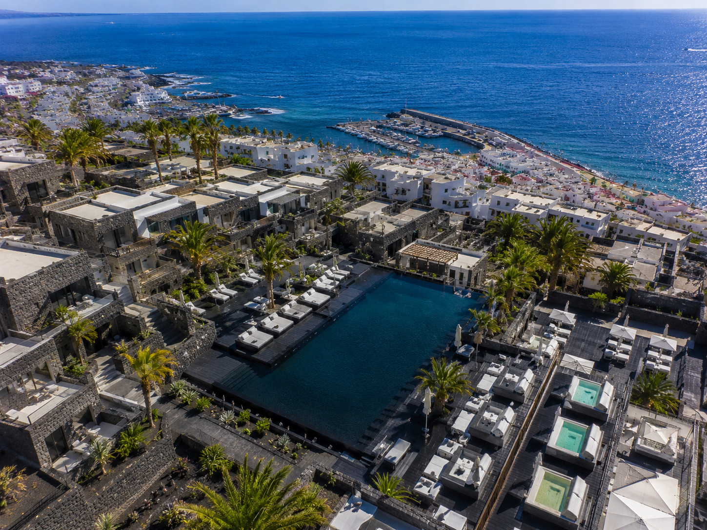 Puerto del Carmen på Lanzarote – helikoptervy över Kanarieöarnas största resort med 7 km strandremsa, vitkalkade hotell och Atlanten