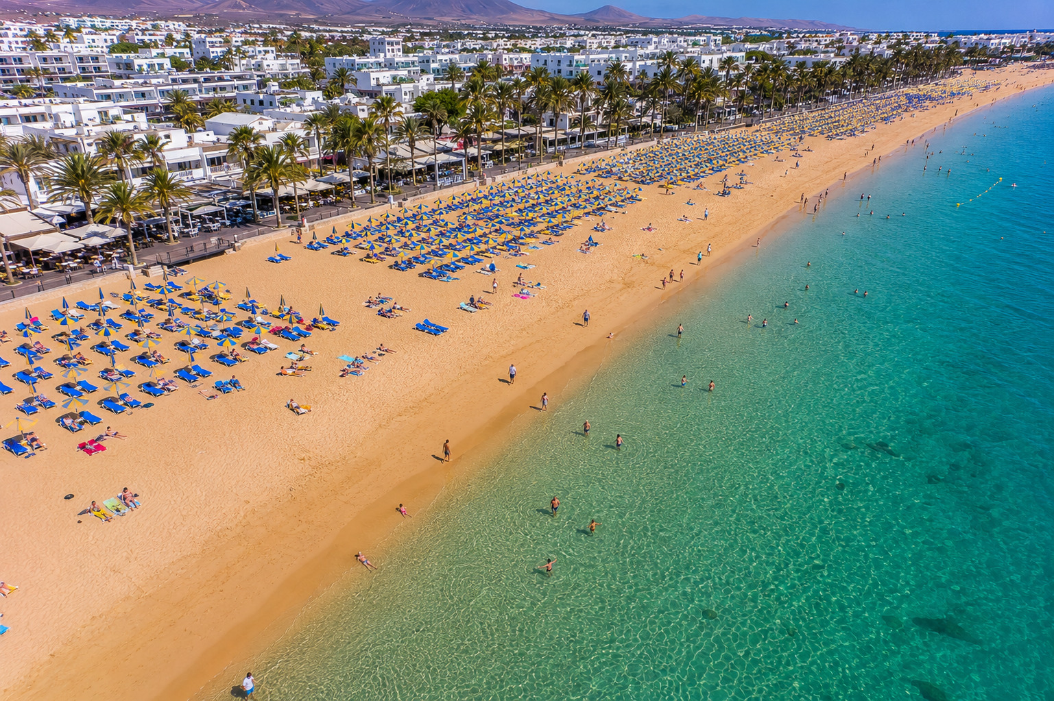 Puerto del Carmen på Lanzarote – helikoptervy över Kanarieöarnas största resort med 7 km strandremsa, vitkalkade hotell och Atlanten