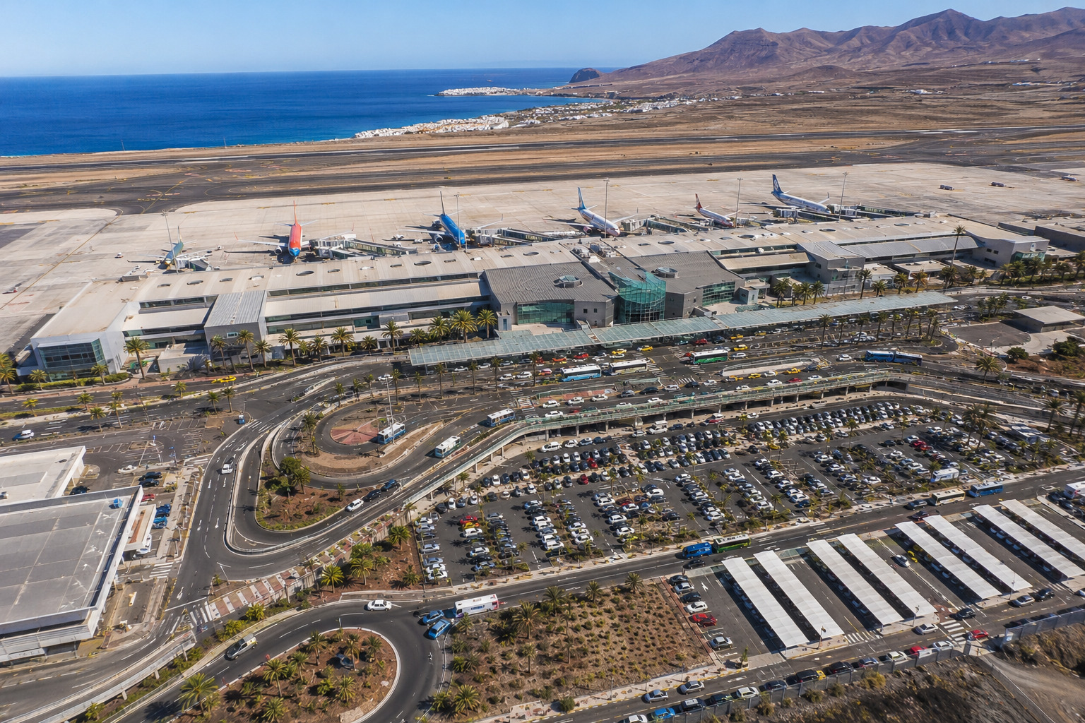 Lanzarotes flygplats (ACE) vid Arrecife – flygplan vid terminalen med Atlanten i bakgrunden